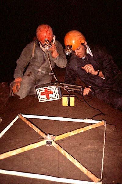 Cavers using cave radio survey equipment inside Rat's Nest Cave, Canmore Alberta — underground positioning technology used during exploration of the Canadian Rockies cave system