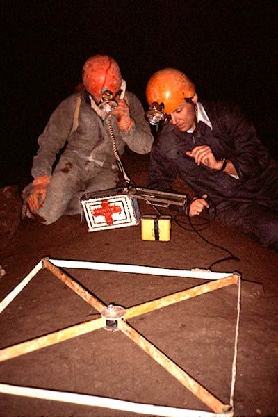 Cavers using cave radio survey equipment inside Rat's Nest Cave, Canmore Alberta — underground positioning technology used during exploration of the Canadian Rockies cave system